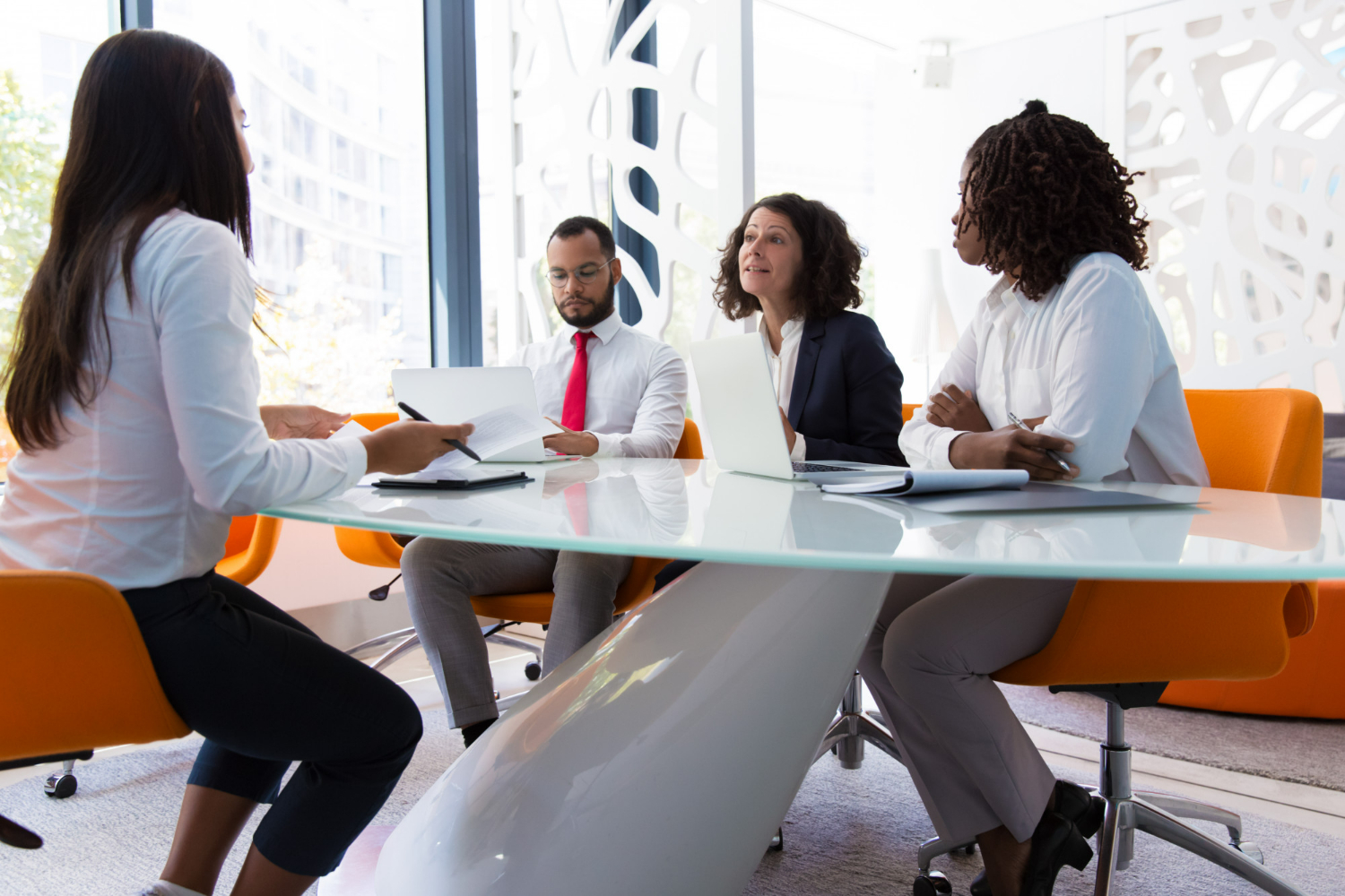 um homem e três mulheres sentados a mesa em reunião de gestão de pessoas